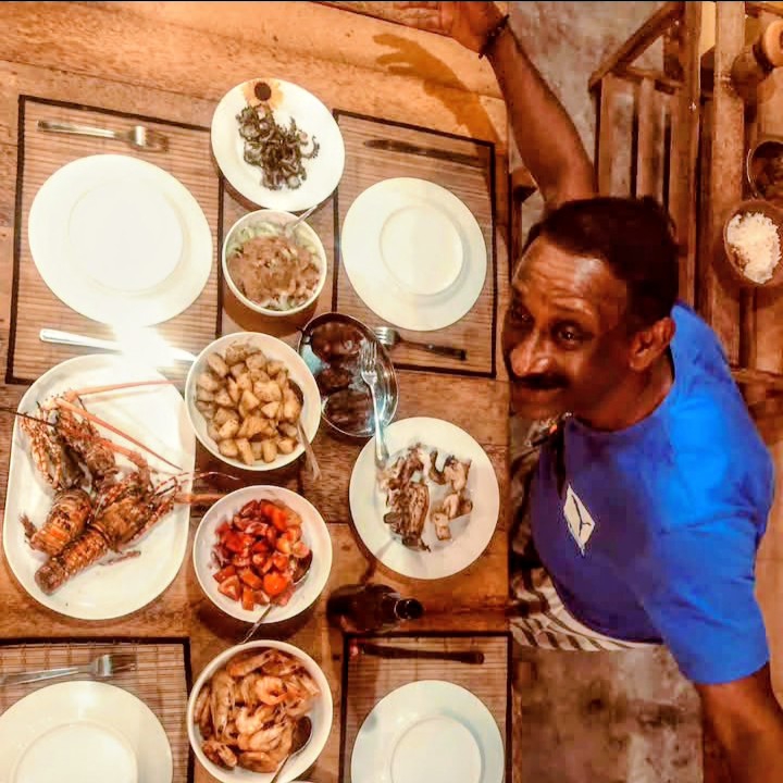 The chef with a fresh seafood spread — lobster, prawns and curries